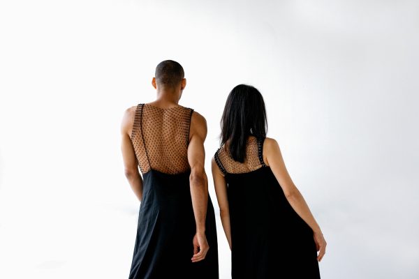 Owen Ridley-Demonick and Jia-Yu Corti face away from the camera wearing mesh dresses