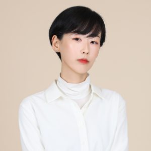 A headshot image of Suyoung Park against a plain beige background